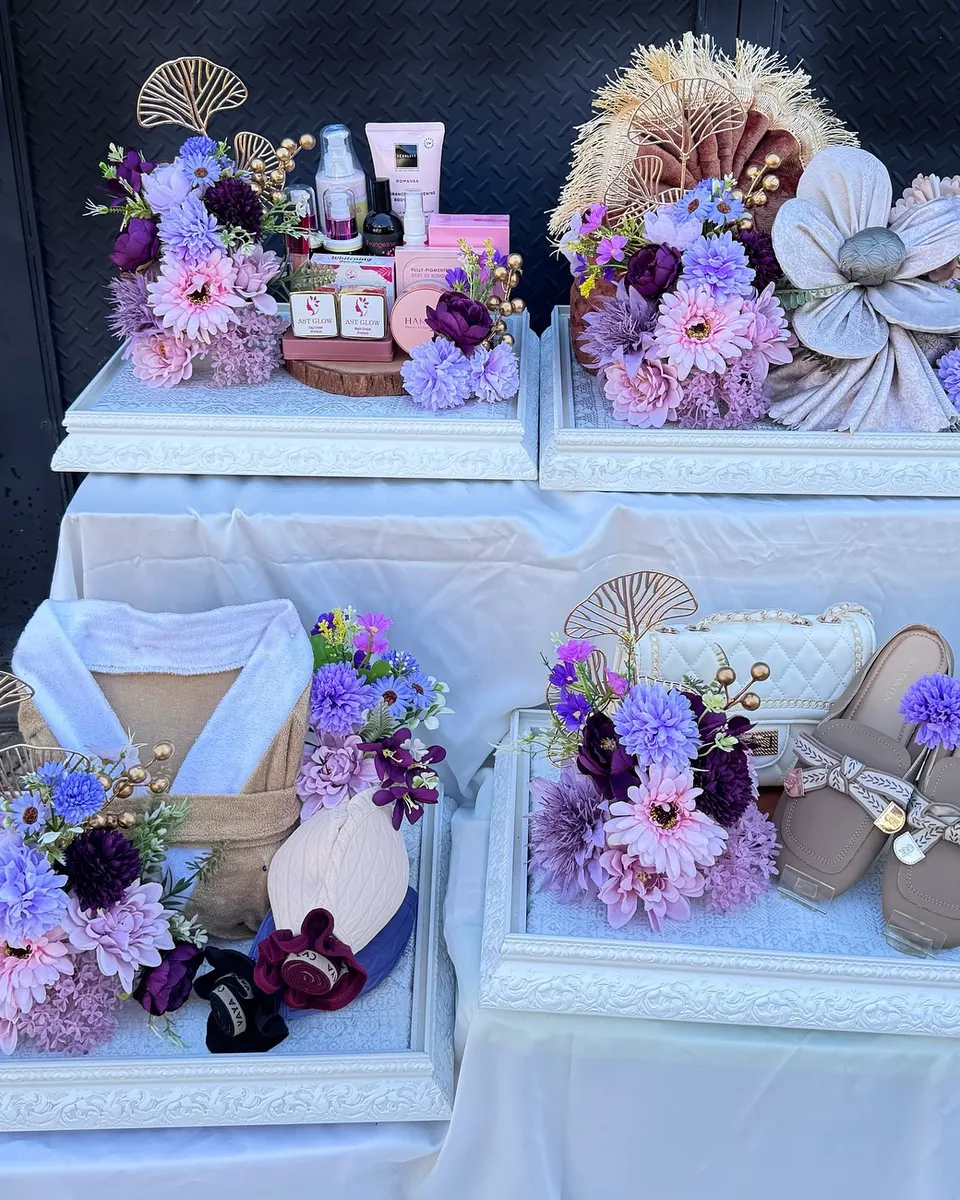 Set seserahan bertingkat bernuansa ungu lilac: kosmetik, mukena, tas, dan sandal dengan bunga ungu dan ginkgo emas